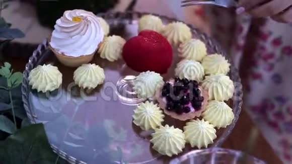 女人切一个心形的蛋糕各种蛋糕放在个水晶圆形的盘子上视频的预览图