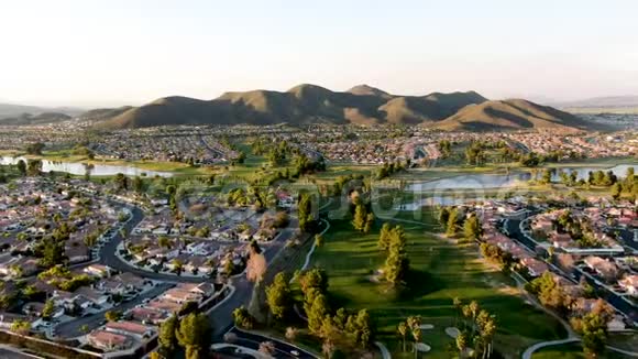 日落时分Temecula周围环绕城镇住宅和豪华别墅的高尔夫球场的空中景观视频的预览图