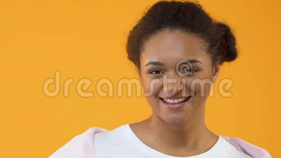 微笑的女时髦手拿着黄色的甜甜圈甜点零食视频的预览图
