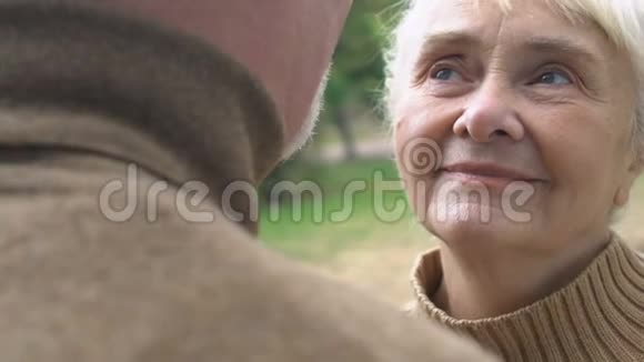 灰发男人亲吻成熟的妻子的脸颊浪漫的时刻幸福视频的预览图
