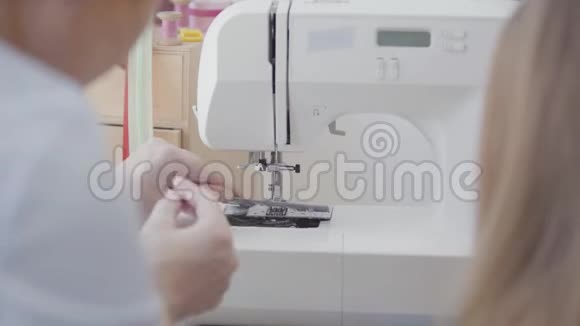 裁缝的特写在开始工作前将线插入缝纫机的针中是个教书的女人视频的预览图