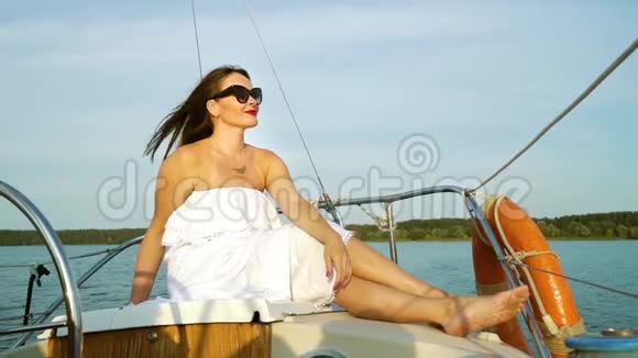 穿着白色裙子享受海上航行的迷人女人视频的预览图