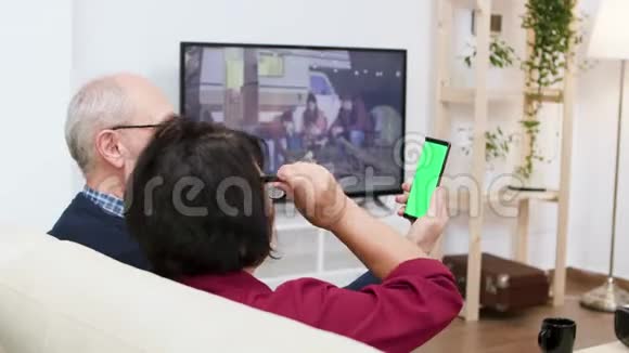 侧视镜头的老夫妇挥舞电话与绿色屏幕视频的预览图
