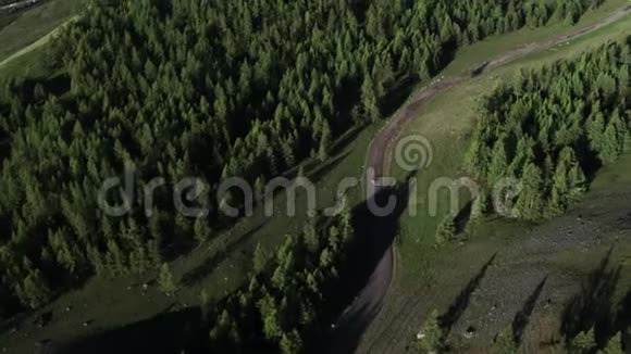航拍4K车行驶在树林中的乡间小路上经过村庄和湖边视频的预览图
