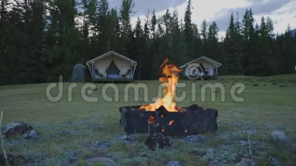 在雪山4K的背景下森林里的野营地发生了火灾视频的预览图