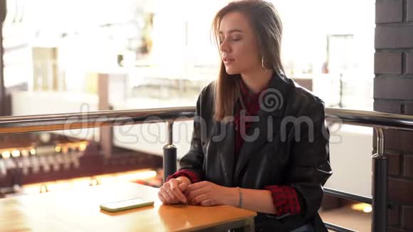 年轻漂亮的白种人女孩坐在咖啡馆里看着手机屏幕听到了坏消息很难过视频的预览图