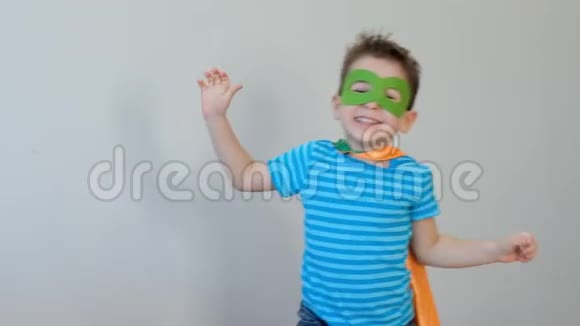 一个强壮自信的男孩穿着超级英雄服装的肖像看着镜头显示二头肌成功的概念开心快乐视频的预览图