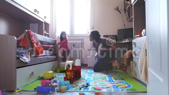 长头发的摇滚歌手爸爸拿玩具吉他和柚木摇滚和金属音乐家给小女儿摆姿势开玩笑视频的预览图