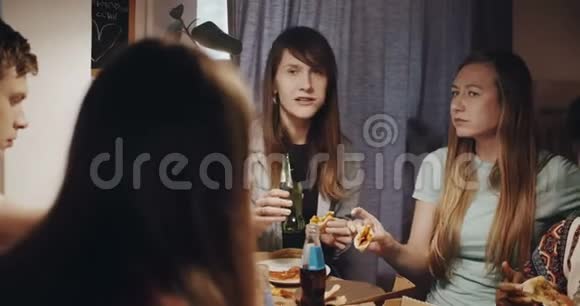 许多年轻男女喜欢吃披萨和饮料在一个休闲的家庭朋友聚会上慢动作视频的预览图