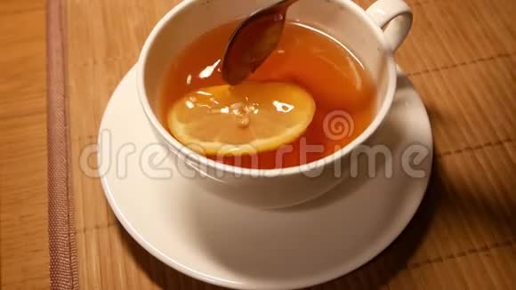 慢动作柠檬茶放在白色杯子里黄色柠檬在表面移动视频的预览图