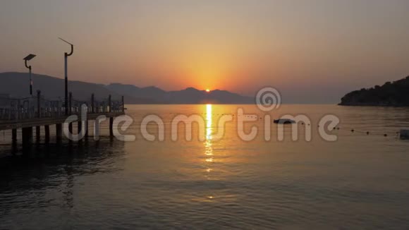 美丽的早晨日出山海景观金色的太阳升起在山的轮廓之上平静的大海视频的预览图