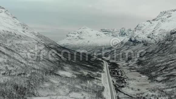 岩石雪山之间道路的空中景观视频的预览图