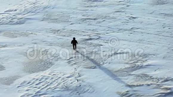 空中观景摄像机跟随穿越雪漠的人视频的预览图