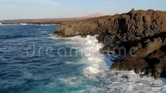 以日落色调鸟瞰熔岩悬崖和海洋加那利群岛兰萨罗特视频的预览图