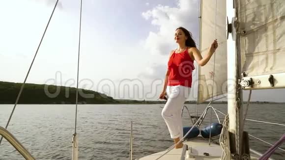 优雅的女人在夏天的帆船上休息视频的预览图