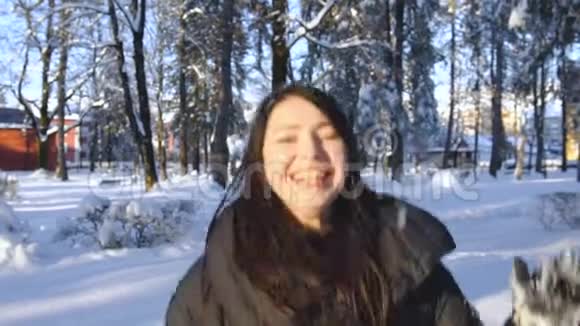 女孩喜欢在冬天的雪地公园里跳跃视频的预览图