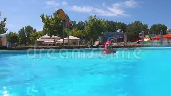 一个晒黑了的女人在游泳池里游泳喷着水视频的预览图