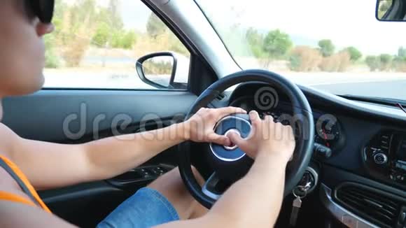 在阳光明媚的夏日一个面目全非的男人手握方向盘开车穿过乡村道路盖盖视频的预览图