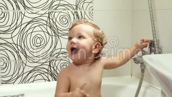 快乐的蓝眼睛宝宝912个月在浴室洗澡玩玩具洗和洗澡孩子卫生和视频的预览图