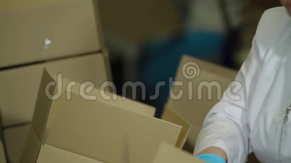 女工人把冰淇淋放进盒子里冰淇淋生产线传送带上的甜点食品生产工艺视频的预览图