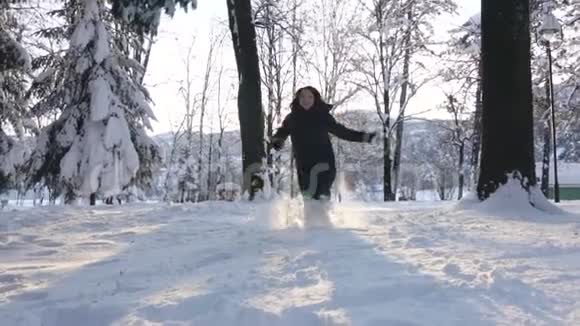 冬天女孩在白雪皑皑的树上奔跑幸福概念视频的预览图