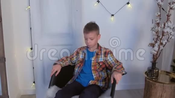 在家里的圣诞室里小男孩在摇椅上摇摆视频的预览图
