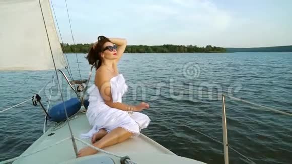 穿着白色裙子的浪漫女孩在帆船上做白日梦视频的预览图