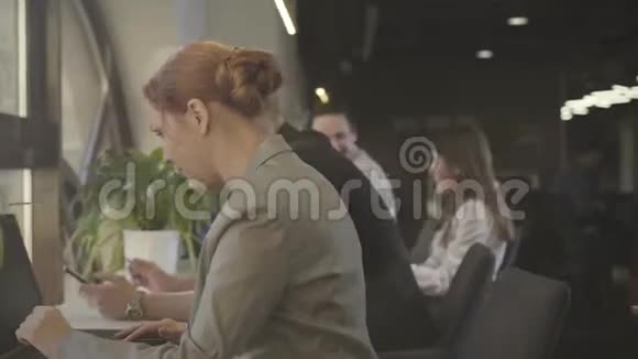 白种人办公室工作人员坐在空地办公室的侧面视图讨论商业项目的男子和妇女视频的预览图