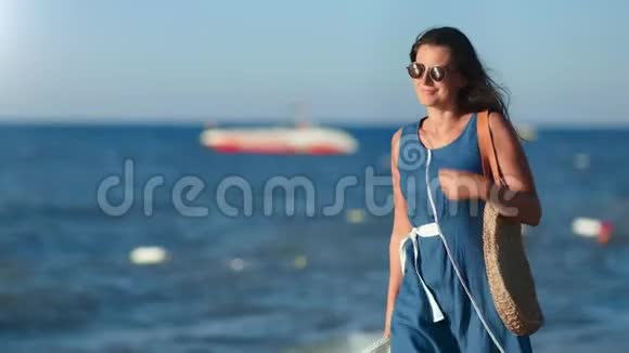 放松的黑发旅行女性在度假期间享受日落海滩散步视频的预览图