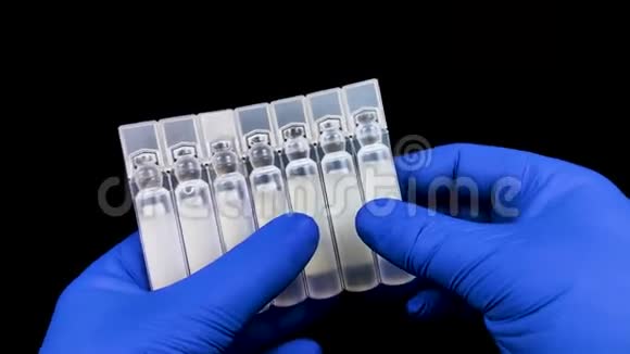 塑料安瓿与药物或疫苗特写戴蓝色手套的医生检查药品宏观视频现代医学视频的预览图
