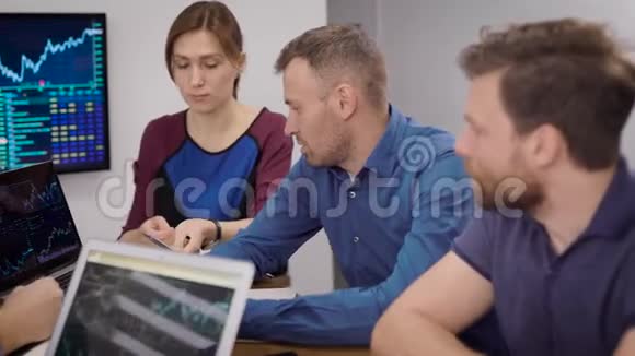 高层管理人员正在查看办公室电脑显示的销售图表和时间表视频的预览图