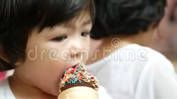 接近小亚洲女孩喜欢吃带有彩虹配料的巧克力冰淇淋婴儿的发展对他们的感觉视频的预览图