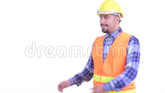 快乐留胡子的波斯人建筑工人一边向后面展示视频的预览图