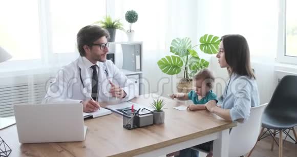 母亲和儿科医生谈论女婴的健康视频的预览图