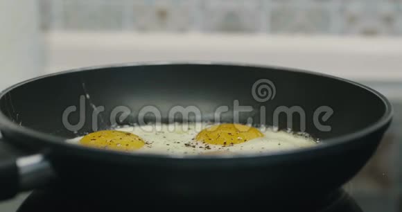 在黑金属锅里煮四个煎蛋煎锅中四个鸡蛋的早餐食品准备电影院4K视频的预览图
