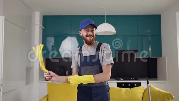 在高科技厨房里一个带着黄手套和跳舞的清洁服务部门留着胡子的滑稽男人视频的预览图