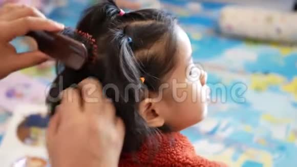 亚洲妈妈的手把她的小女儿头发整理好了妈妈的爱和关怀妈妈视频的预览图