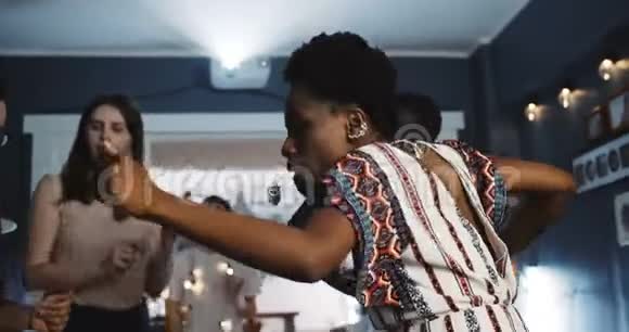 快乐的年轻微笑的非洲妇女与多民族的朋友跳舞在学生聚会庆祝节日慢动作视频的预览图