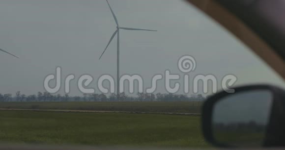 旋转风力发电机在现场从汽车窗口查看风的力量清洁和可再生能源解决方案视频的预览图