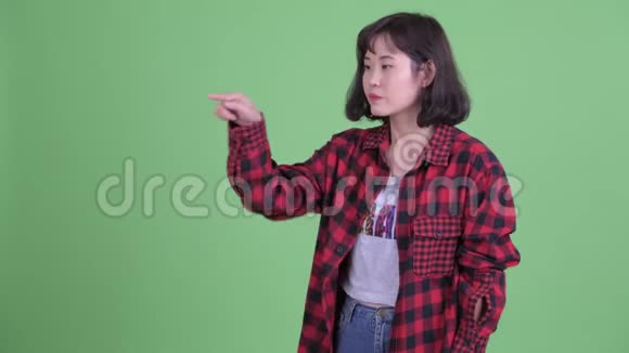 穿着亚洲时髦的女人摸东西看上去很生气视频的预览图