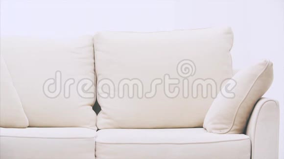 可爱的白种人女孩躺在沙发上把腿放在沙发的背面用电话短信微笑视频的预览图