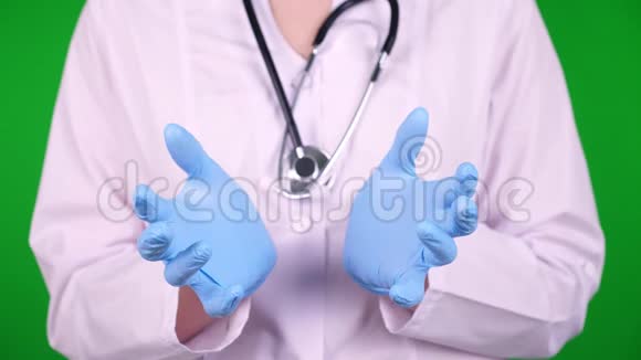 特写镜头医生穿着白色的医疗制服用听诊器用手拿着绿色的东西视频的预览图