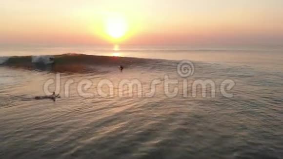 在温暖的夕阳下用波浪和冲浪者俯瞰海洋视频的预览图