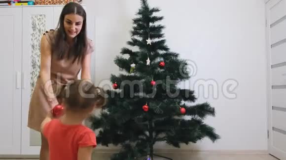 快乐的妈妈和小女儿在家装饰圣诞树概念家庭寒假和人视频的预览图