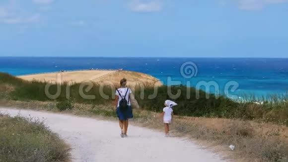 母亲和女婴走在通往地中海的小径上视频的预览图