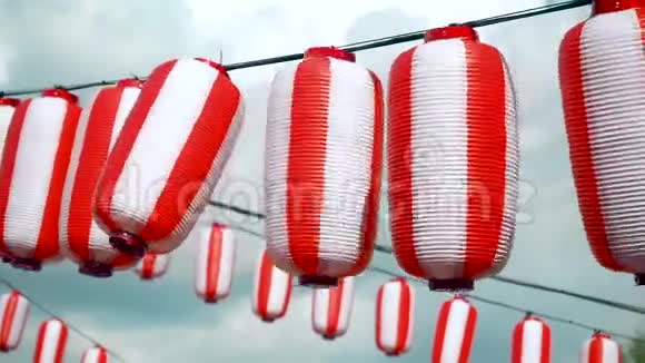 许多东方纸红白灯笼楚钦挂在白色多云的蓝天背景上日本挂的灯笼视频的预览图