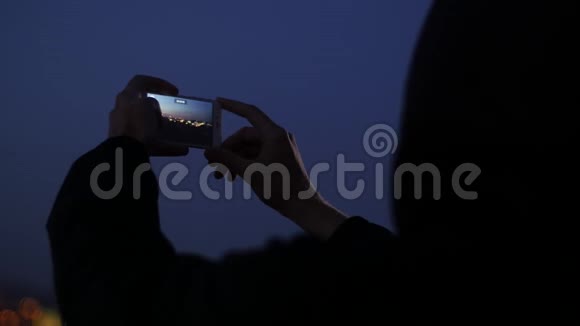 男人用手机拍摄夜晚全景视频的预览图