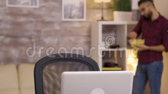 一个女孩在客厅的笔记本电脑里微笑视频的预览图