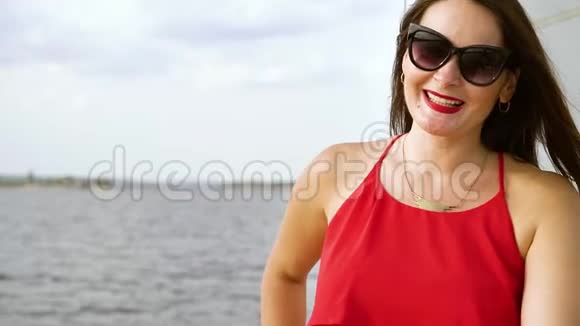 在帆船上摆着墨镜的魅力女孩视频的预览图