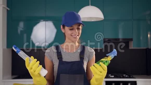 穿着工作服在两种清洁剂中选择绿色洗涤剂的迷人开朗的女人正处于当代视频的预览图